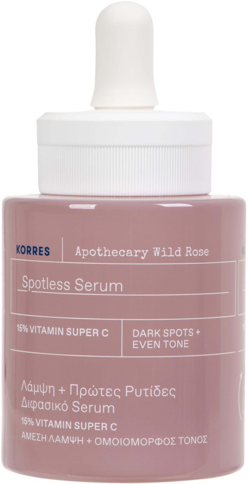 A small, pink bottle with a white dropper cap, labeled 'Korres Apothecary Wild Rose Spotless Serum' and mentions vitamin C.