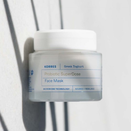 A jar labeled 'Probiotic SuperDose Face Mask' sits on a white surface with a shadow.