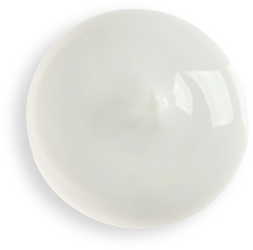 A white, shiny, smooth round ball sitting on a white surface with reflected light.