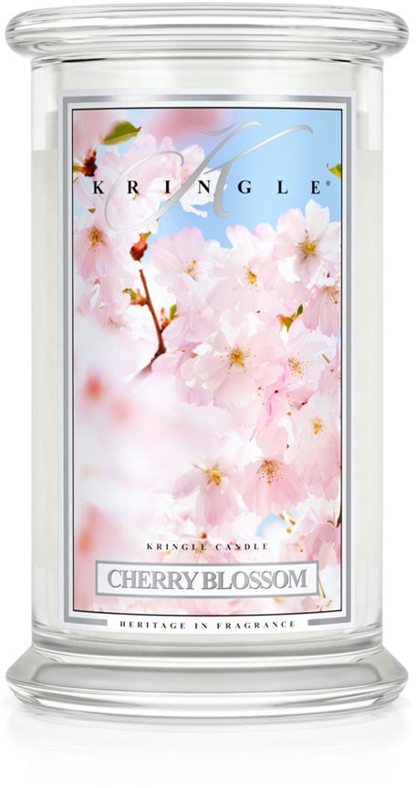 Een geurkaars met kersenbloesem ontwerp en doorzichtige glazen houder, gemarkeerd 'Cherry Blossom' en 'Heritage in Fragrance.'