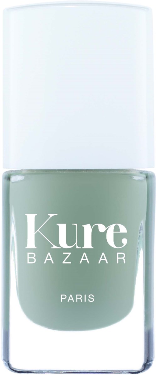 Ein Nagellackflasche mit dem Etikett 'Kure BAZAAR PARIS', weißer Deckel, grau-grüne Farbe.