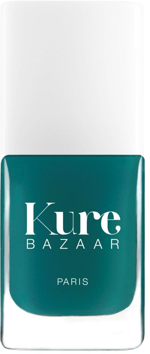 Ein Nagellackflasche mit weißem Deckel und türkisfarbener Etikette, die die Worte "Kure BAZAAR PARIS" zeigt.