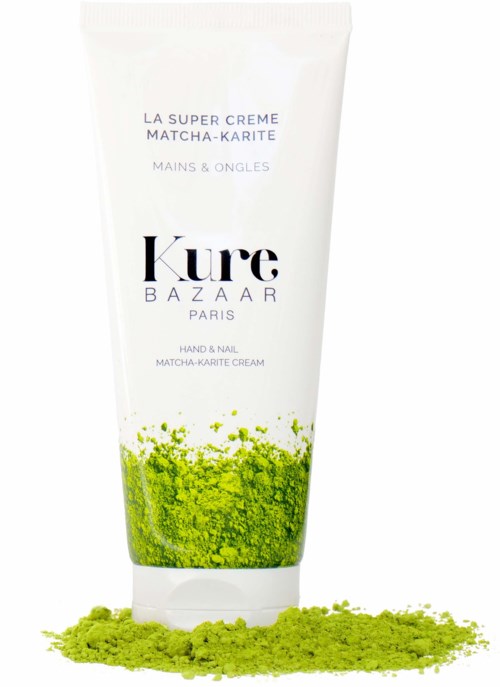 A white tube of hand and nail cream with green matcha powder spread at the base.
