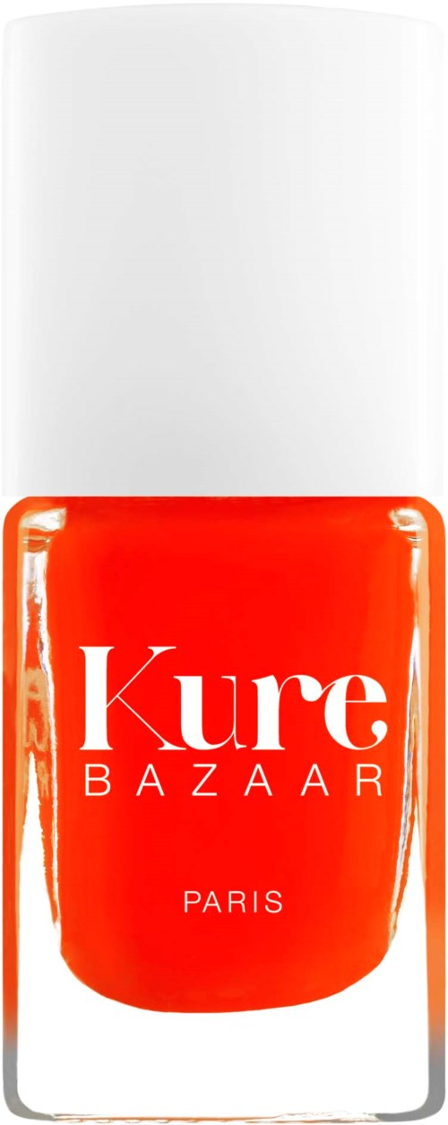 Eine Flasche orangefarbigen Nagellacks mit weißen Deckel, gekennzeichnet 'Kure Bazaar Paris'.