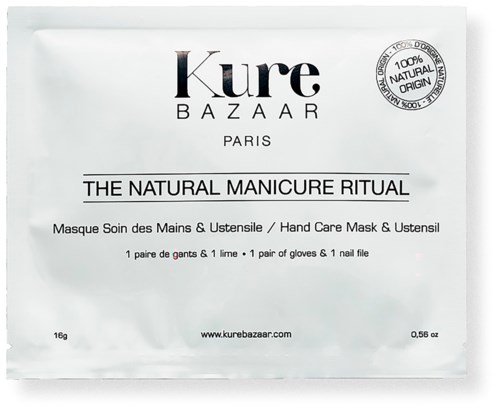 Et lite hvitt pakk merket 'Kure Bazaar' inneholder en håndpleie maske med hansker og en neglefil, med vekt på naturlige ingredienser.