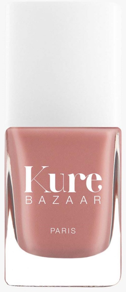 Eine rosa Nagellackflasche mit weißen Schriftzug, vor ihrer weißen Verpackung.