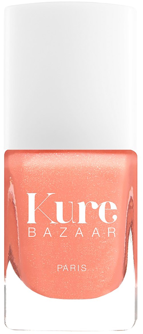 Ein Nagellackflasche mit pink-orange Farbe und weißem Deckel, beschriftet 'Kure BAZAAR PARIS'.
