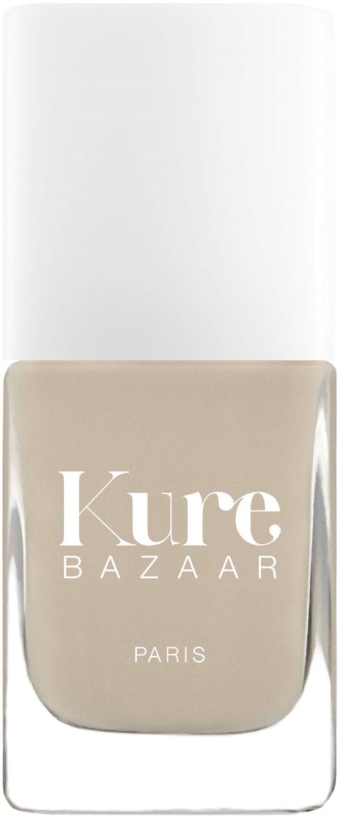 Ein beiger Nagellackflasche von Kure Bazaar mit weißem Deckel. Markenname und Paris sind auf der Flasche.