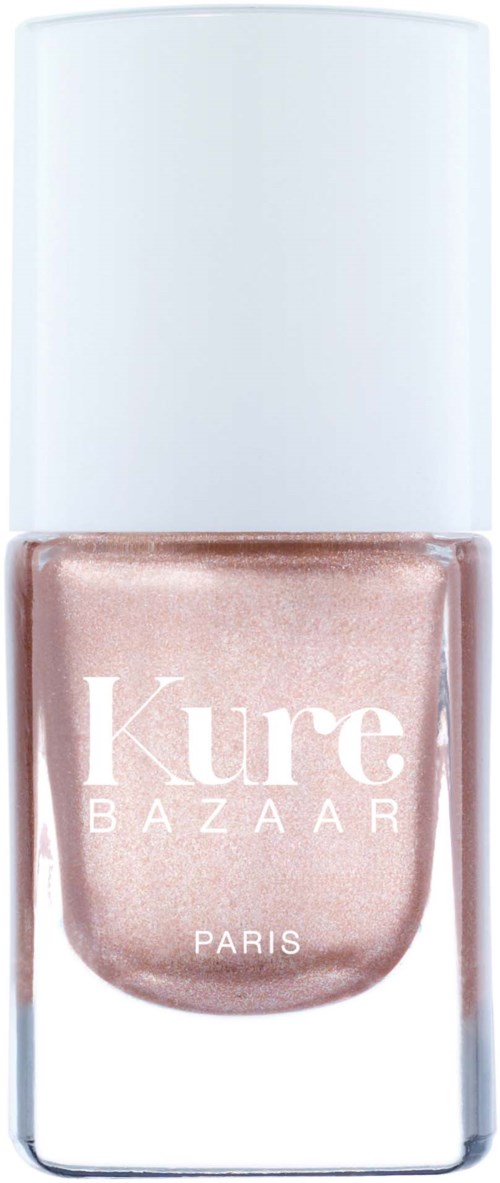 Eine Glasflasche mit Nagellack und weißem Deckel, beschriftet "Kure BAZAAR PARIS," enthält einen hellen, schimmernden pinken Nagellack.