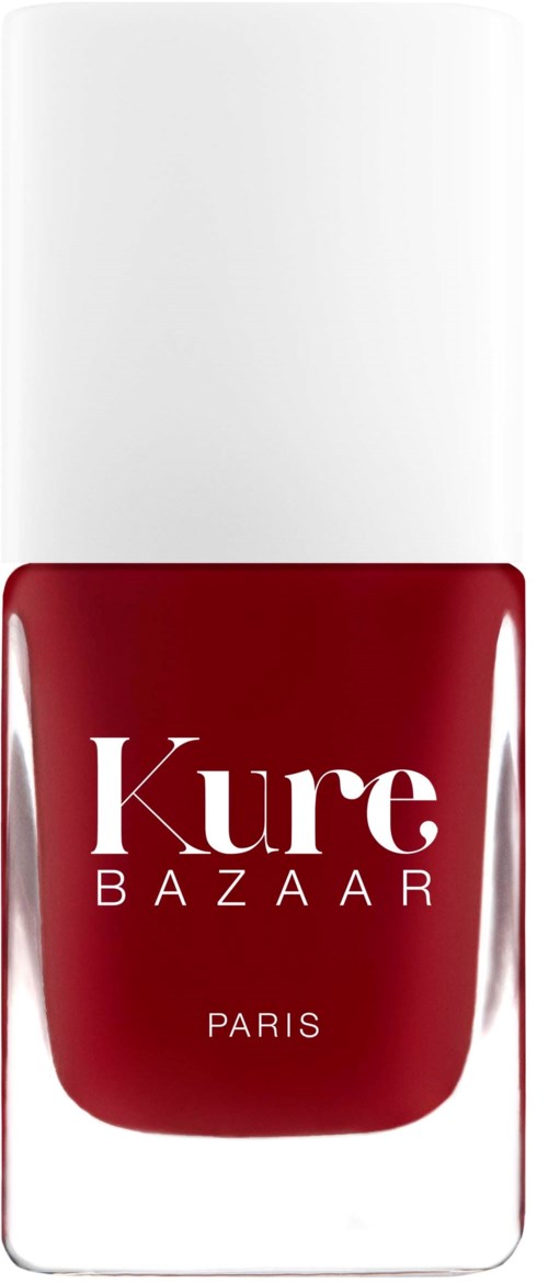 Eine rote Nagellackflasche mit weißem Deckel und der Aufschrift 'Kure BAZAAR PARIS'.