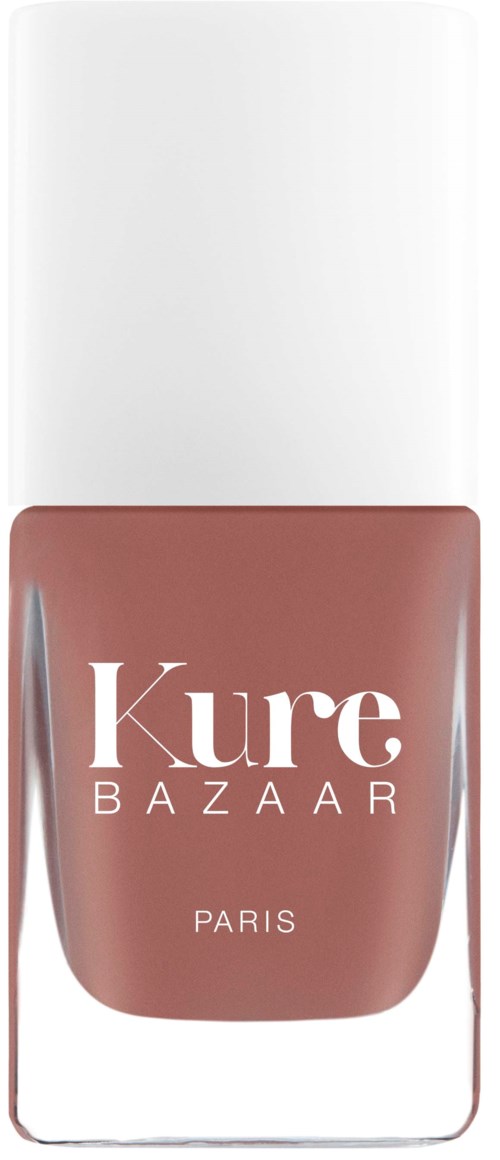 Ein Nagellackflasche mit der Aufschrift 'Kure Bazaar Paris' mit weißem Deckel und brauner Farbe.