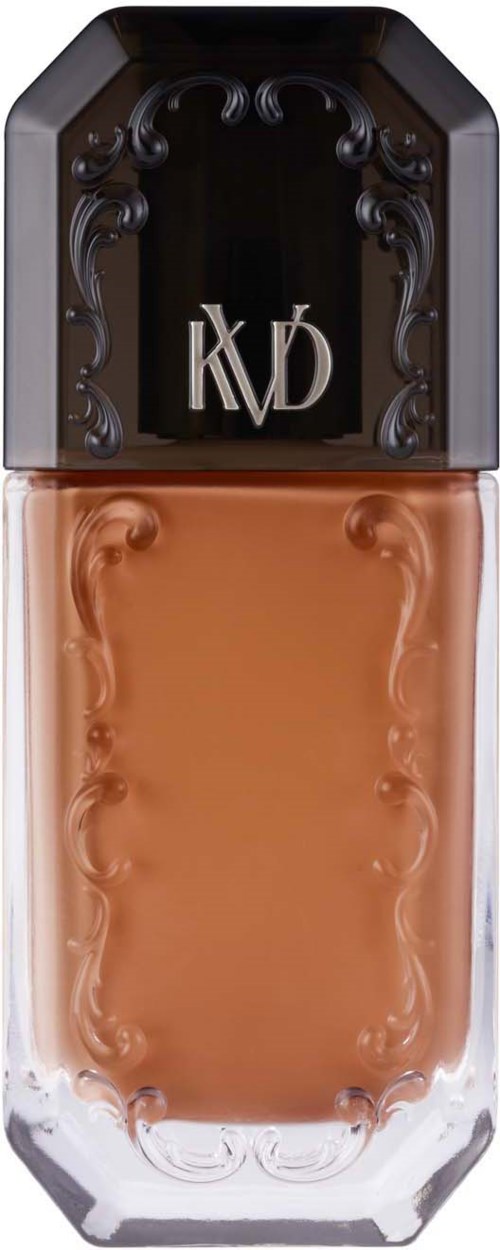 Een fles foundation met een zwart deksel en decoratieve details, met de letters 'KVD'.