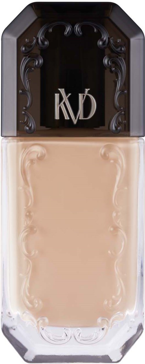 En flaska med beige flytande foundation med svampformig kapsyl med dekorativa element och initialerna 'KVD'.