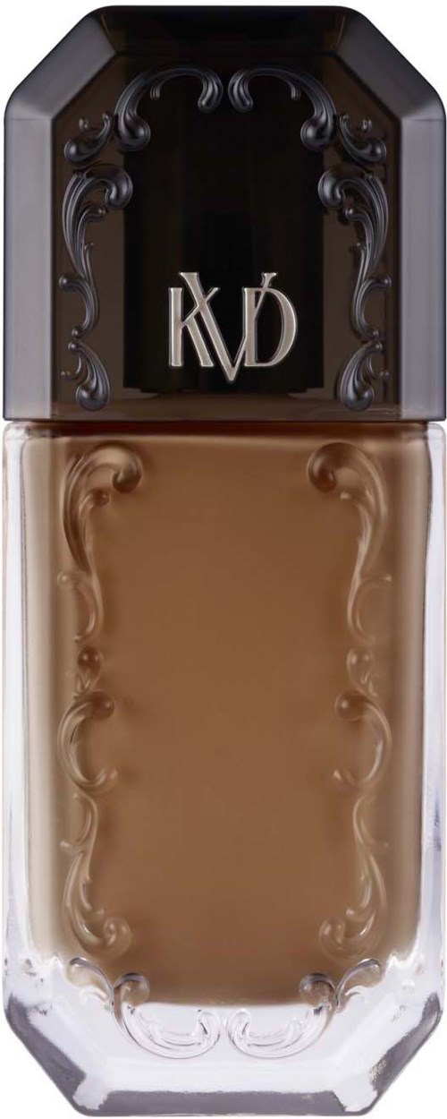 En makeupfoundationflaska med svart lock, vitt märke och beige vätska inuti.