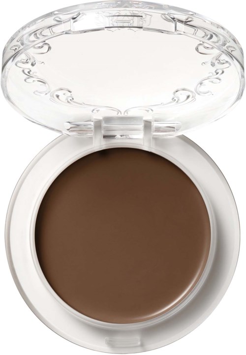 En liten rund behållare med brunt fast makeup och ett klart, öppet plastlock.