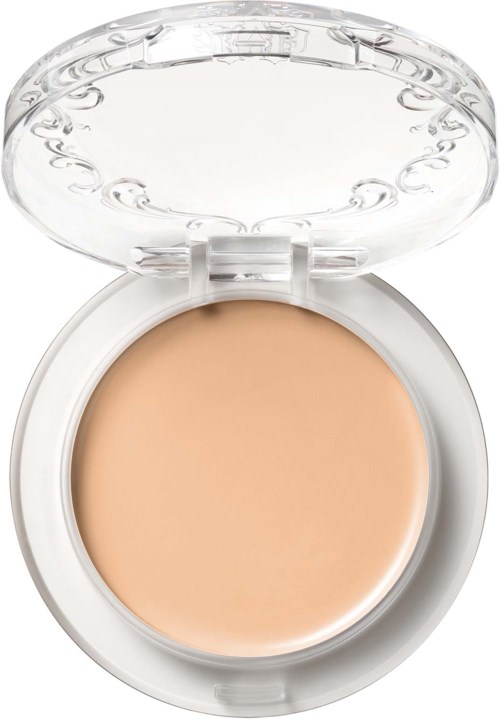 En liten dosa med beige kräm inuti, genomskinlig lock och enkel rund form.