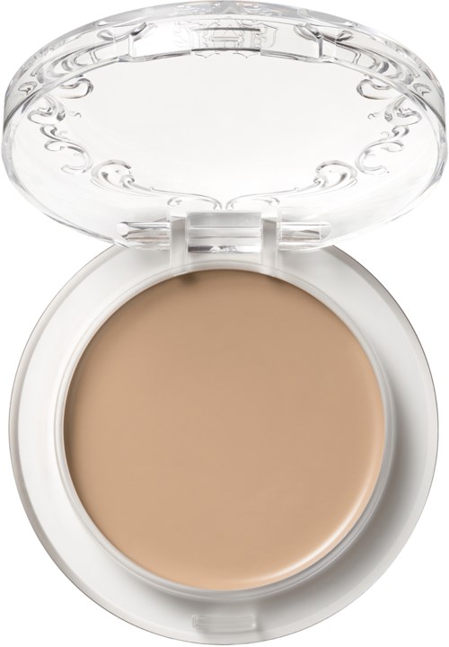 En liten dosa med beige kräm inuti och ett klart lock, används för makeup.
