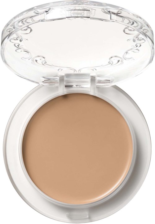 En sminkask med beige foundation inuti och ett tydligt lock med dekorativa detaljer.