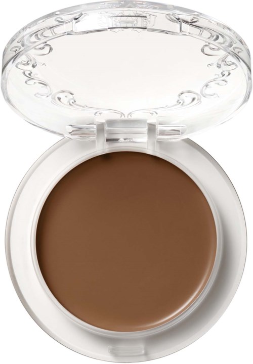 En brun makeupprodukt i en rund vit behållare med ett genomskinligt lock som kan öppnas.