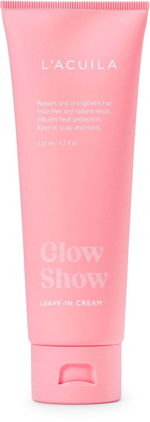 Roze tube met label 'L'ACULA Glow Show Leave-In Cream' voor haarverzorging. Eenvoudig ontwerp met productnaam en beschrijving.