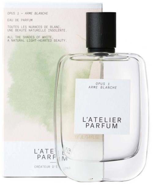 A clear perfume bottle with a black cap, label reading 'L'ATELIER PARFUM,' and a soft, pastel background.