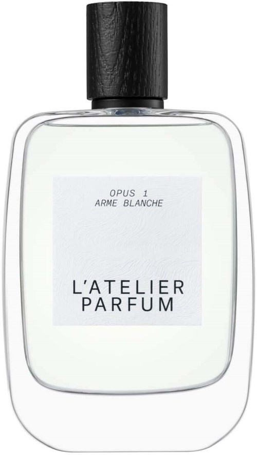 A perfume bottle with black cap, clear glass, and white label saying "Opus 1 Arme Blanche" and "L'atelier Parfum."