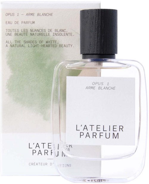 A clear perfume bottle with a black cap in front of a white and green box. The box has text in French and English.