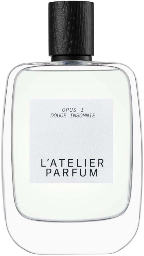 A perfume bottle with a black cap and white label. The label shows "L'ATELIER PARFUM" and some text.