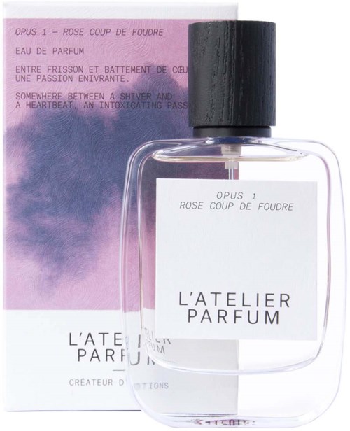 A perfume bottle labeled 'L'Atelier Parfum' with pink and purple box behind it, scent named 'Opus 1 - Rose Coup de Foudre.'