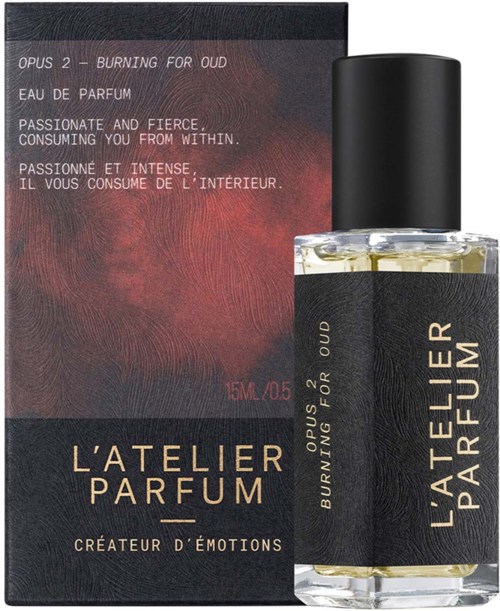 A perfume bottle and box labeled 'L'Atelier Parfum: Burning for Oud,' with descriptions in English and French about passion.