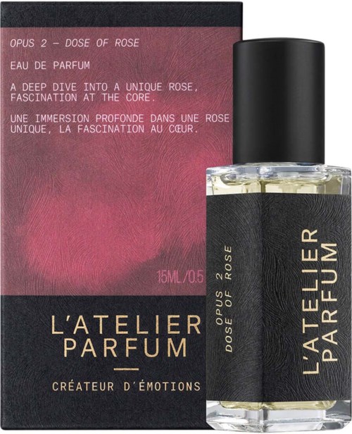 A perfume bottle and box feature a deep rose color theme, with text describing a unique rose scent. The bottle is clear with a black cap.