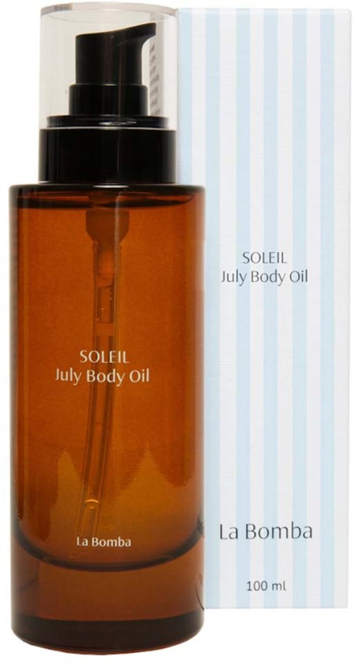 Gullfarget flaske med Soleil July Body Oil med svart pumpe, ved siden av en blå stripete eske.