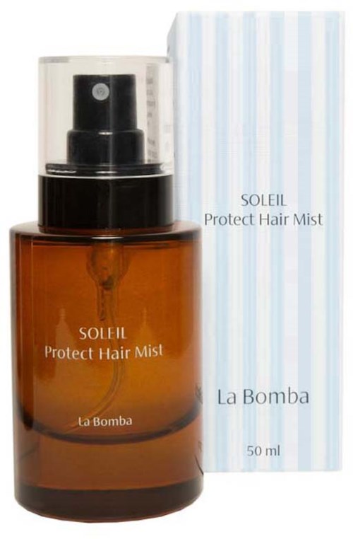 En brun sprayflaske av Soleil Protect Hair Mist med klar lokk, vist ved siden av den hvite og blå stripete esken.