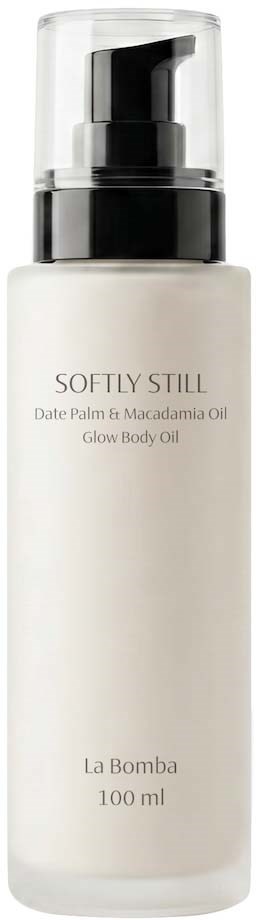 En hvit flaske med svart pumpe merket Softly Still Date Palm & Macadamia Oil Glow Body Oil av La Bomba, 100 ml.