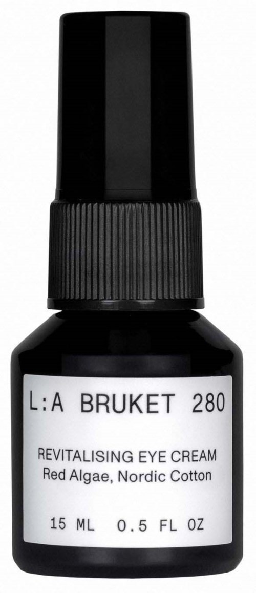 Kleine schwarze Flasche mit weißem Etikett, beschreibt Augencreme mit roten Algen und nordischer Baumwolle. Sie hat eine Pumpe.