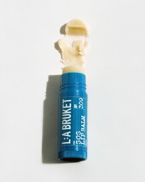 Ein blauer Lippenbalsstift mit weißer Creme, die herauskommt, und etwas Creme oben.