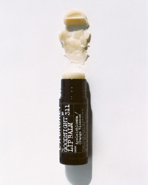 Ein Lippenbalsamstick mit etwas ausgelaufenem Balsam auf einer weißen Oberfläche.