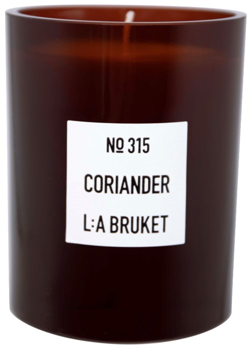 Een bruine kaarsenhouder met een wit label met 'No 315 Coriander L:A Bruket'.