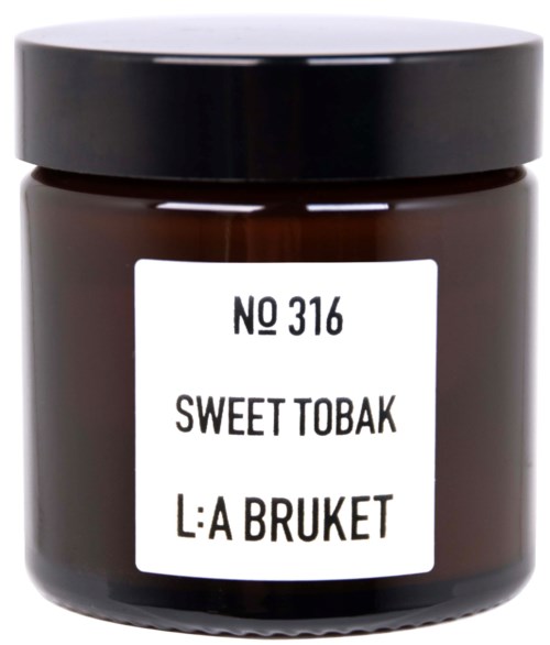 Een klein bruin glazen potje met zwarte deksel, label "Sweet Tobak" en "L:A Bruket".