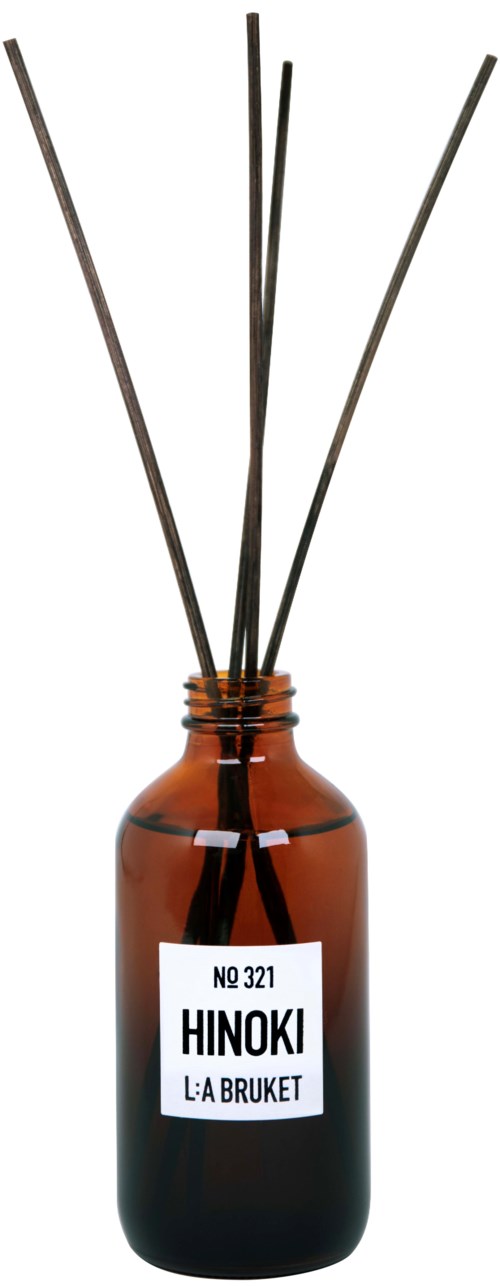 Eine braune Glasflasche mit einem weißen Etikett, auf dem "HINOKI" und "LA BRUKET" steht, und mehreren schwarzen Röstern.