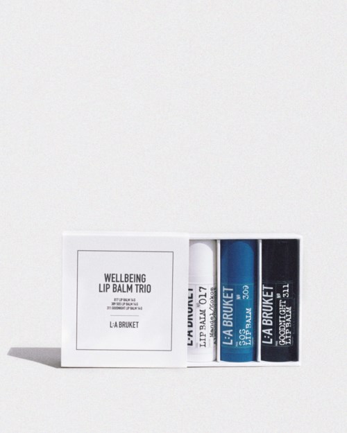 Ein Set aus drei Lippenbalsamen in einer weißen Schachtel mit einfacher schwarzer Schrift und blauer sowie schwarzer Verpackung.