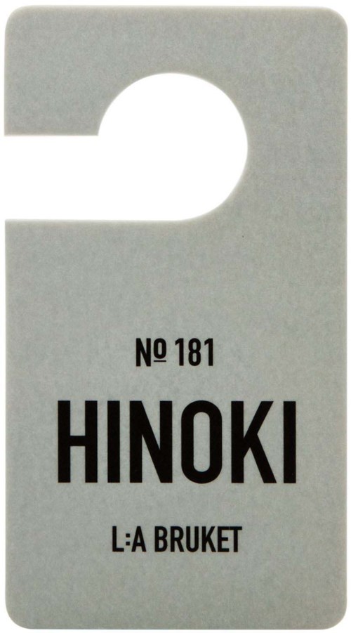 Kleines graues Etikett mit einem Loch oben, zeigt den Text: NO 181, HINOKI, L:A BRUKET.