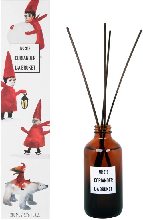 Ruskea diffuuseroidunppi, jossa on numero 318 ja nimi Korianteri, L:A Bruket -merkkinen, varsi nesteeseen. Paketin kuvassa tonttuja ja koira.
