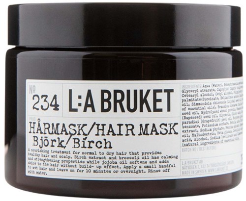 Ein schwarzer Behälter mit der Aufschrift 'L:A BRUKET' und einem weißen Etikett, das Haarmaske mit Birke angibt. Grundlegende Anweisungen sind teilweise sichtbar.