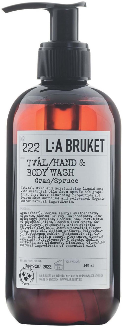 Een bruine fles met een zwarte pomp bevat hand- en lichaamswas met het label 'L:A BRUKET', geur 'Gran/Spruce', en gedetailleerde tekst.