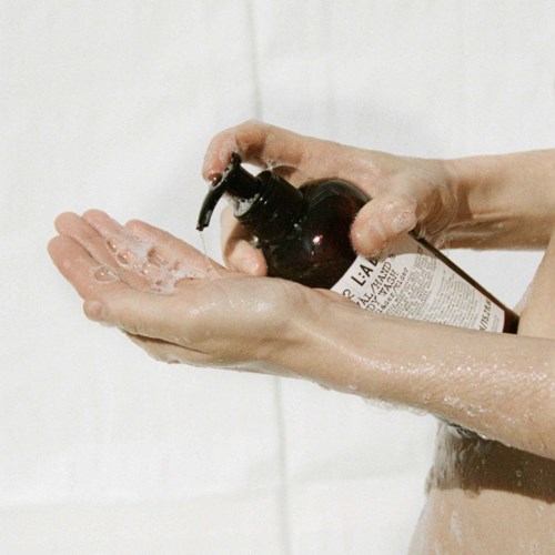 A person is applying liquid soap or hand sanitizer with a pump to their hands.