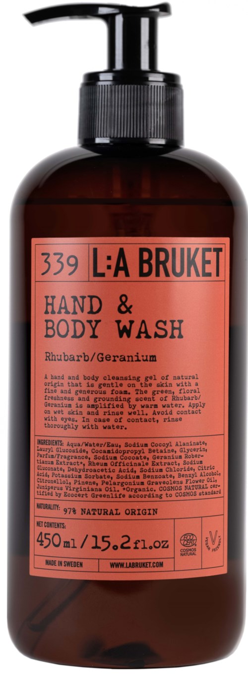 En brun flaska med svart pump innehåller L:A Bruket hand- och kroppstvål med röd och svart etikett.