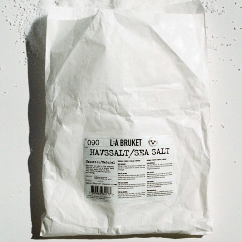 Eine zerknitterte weiße Papiertüte mit einem Etikett, das "Sea Salt" und Produktdetails zeigt.