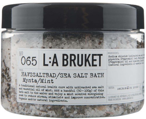 Zoutzeep badproduct met kalmerende muntgeur in doorzichtige container met witte label.