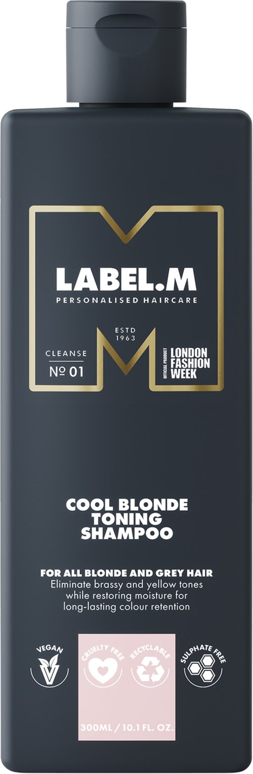 En mörkgrå flaska med LABELE.M schampo för blonda och grå hår. Den har guld- och vittext samt symboler.